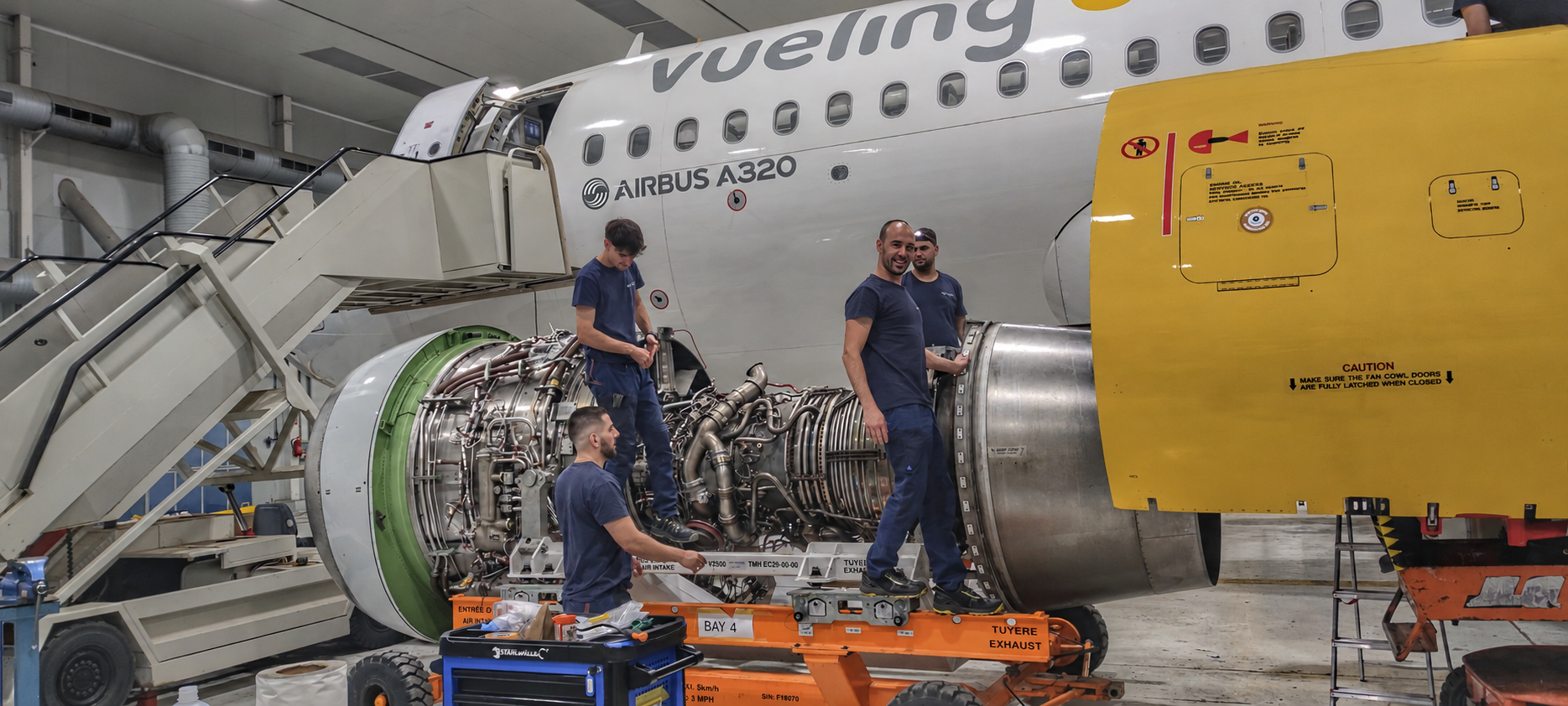Technicians next to an engine