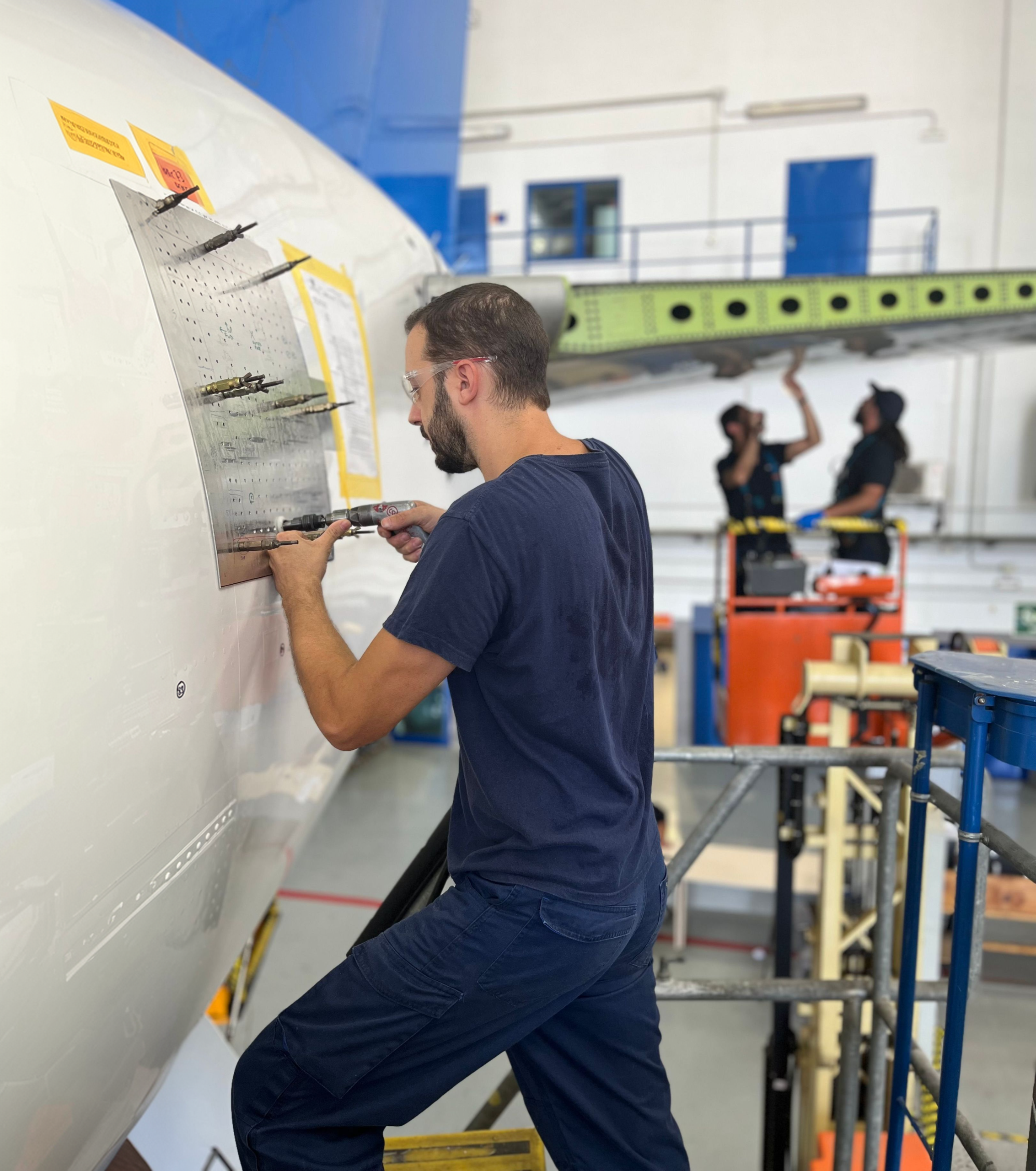 Técnico de mantenimiento trabajando en el fuselaje de un avión